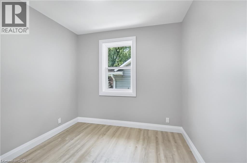 Neutral-toned room with light gray walls, wood-finish flooring, and white baseboards - 10 Comet Avenue Unit# #1 (Main), Hamilton, ON - Indoor Photo Showing Other Room