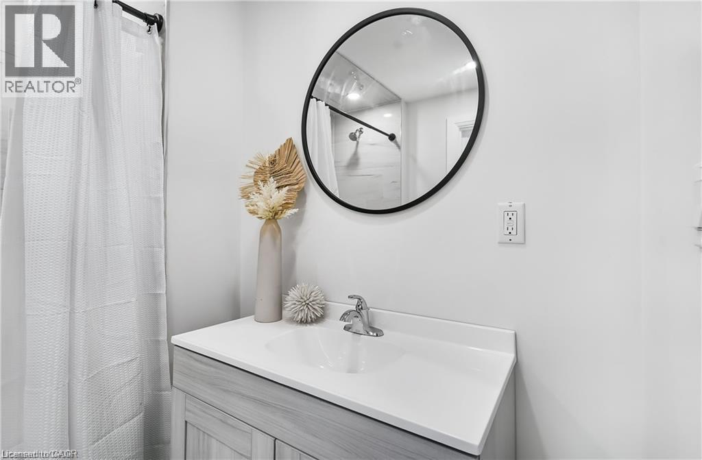 Vanity with integrated sink, chrome faucet, and light wood-finish cabinetry - 10 Comet Avenue Unit# #1 (Main), Hamilton, ON - Indoor Photo Showing Bathroom