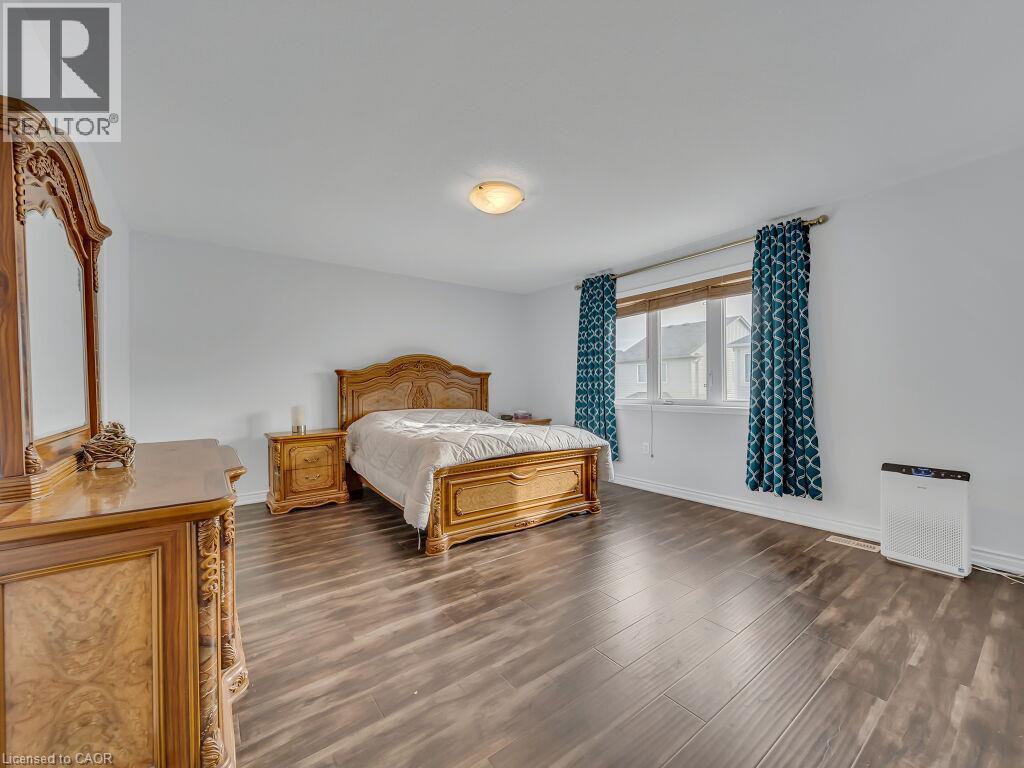 Spacious room featuring wood-finish flooring, a centered window, and a ceiling-mounted light fixture - 227 Baldwin Drive Unit# Main, Cambridge, ON - Indoor Photo Showing Bedroom