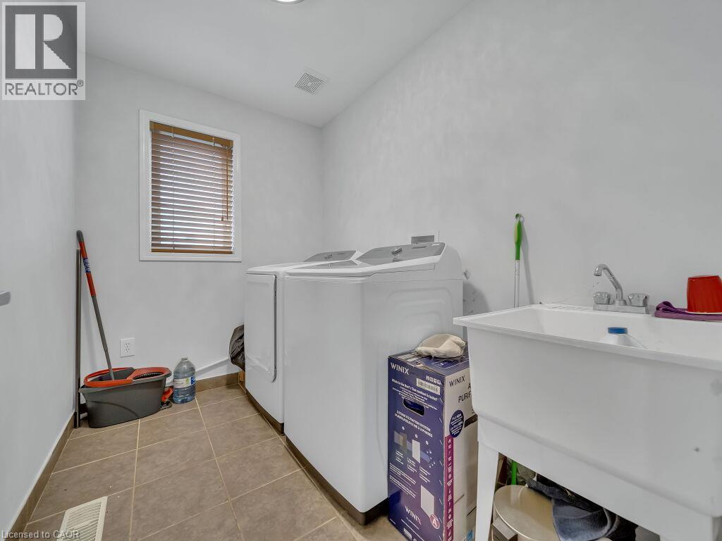 Utility room featuring tiled flooring and a window with wood-finish blinds - 227 Baldwin Drive Unit# Main, Cambridge, ON - Indoor Photo Showing Laundry Room