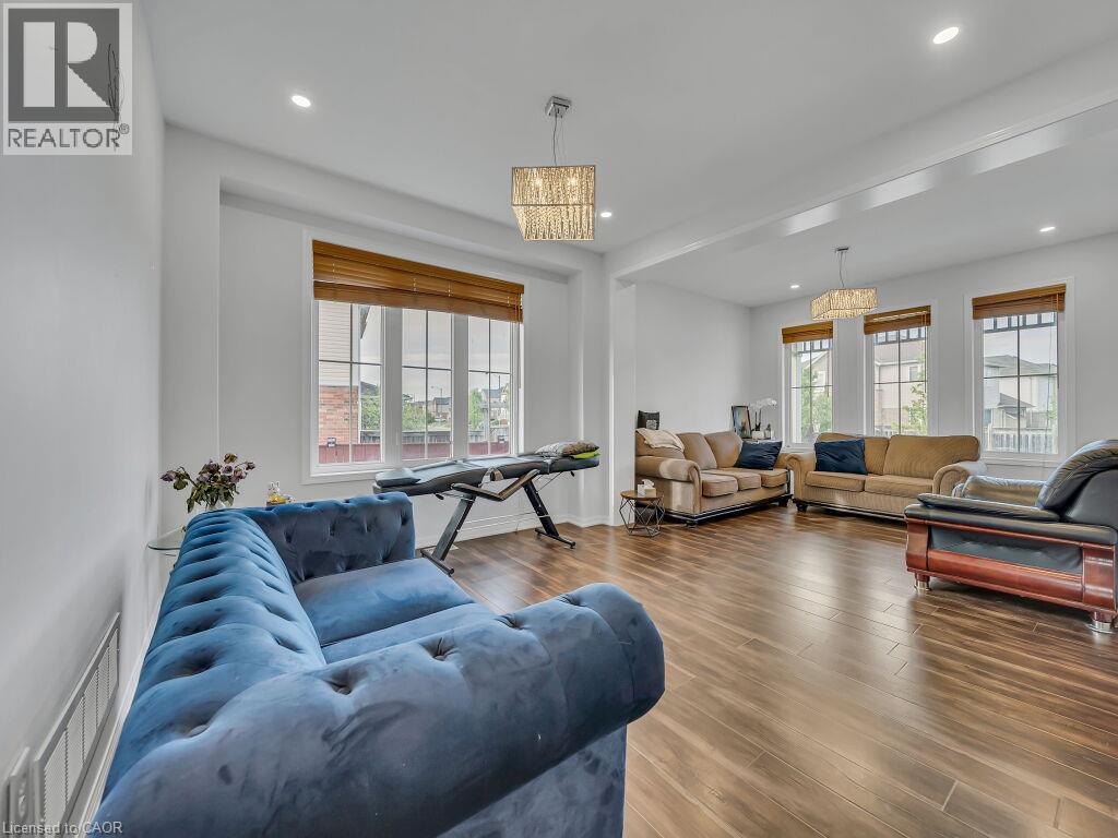 Recessed lighting, wood-finish flooring, multiple windows with blinds, and decorative light fixtures - 227 Baldwin Drive Unit# Main, Cambridge, ON - Indoor Photo Showing Living Room