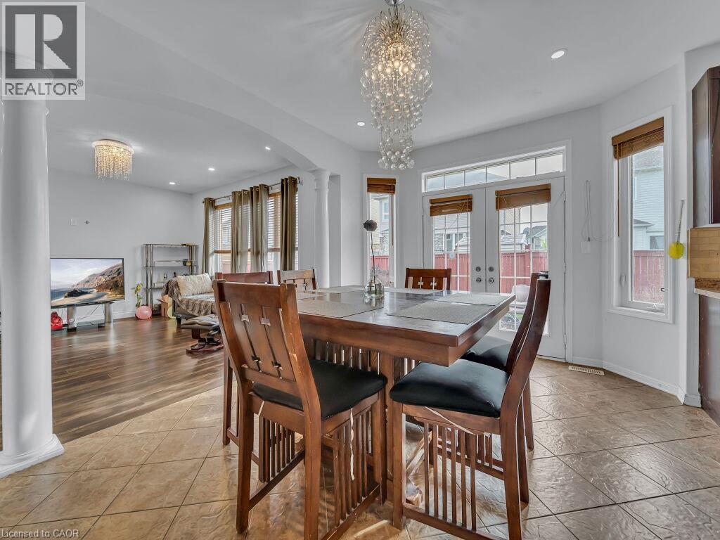 Two-story windows and patio doors, recessed lighting, and a crystal chandelier - 227 Baldwin Drive Unit# Main, Cambridge, ON - Indoor Photo Showing Dining Room
