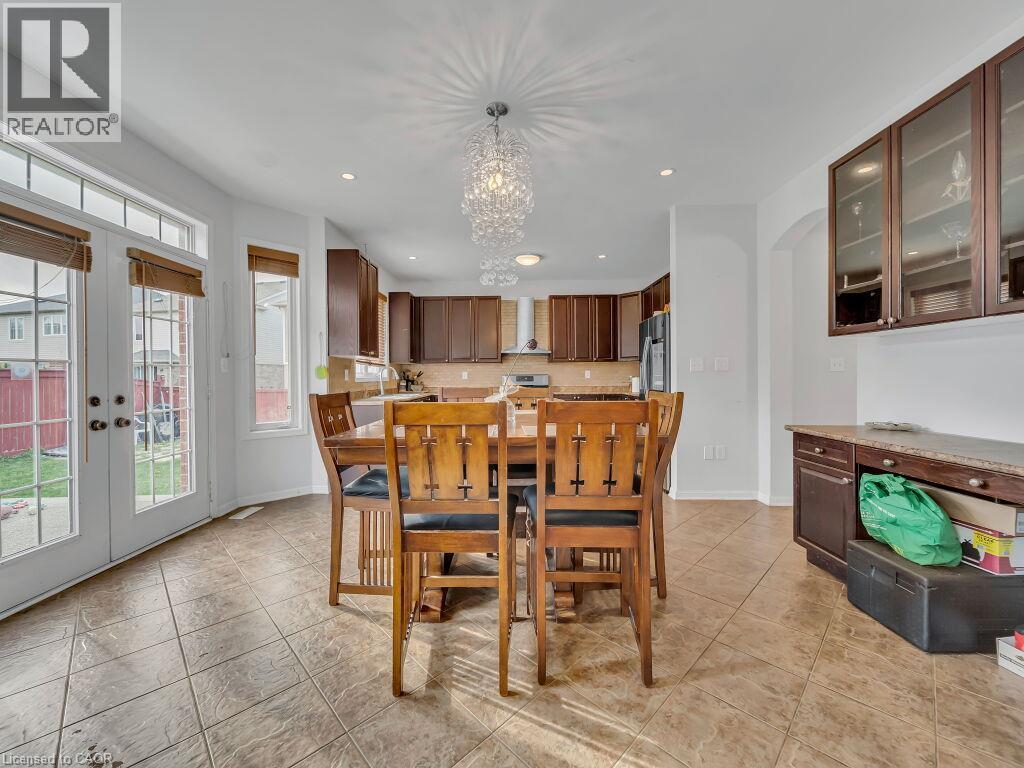 Spacious dining area featuring tile flooring and a decorative chandelier - 227 Baldwin Drive Unit# Main, Cambridge, ON - Indoor Photo Showing Dining Room