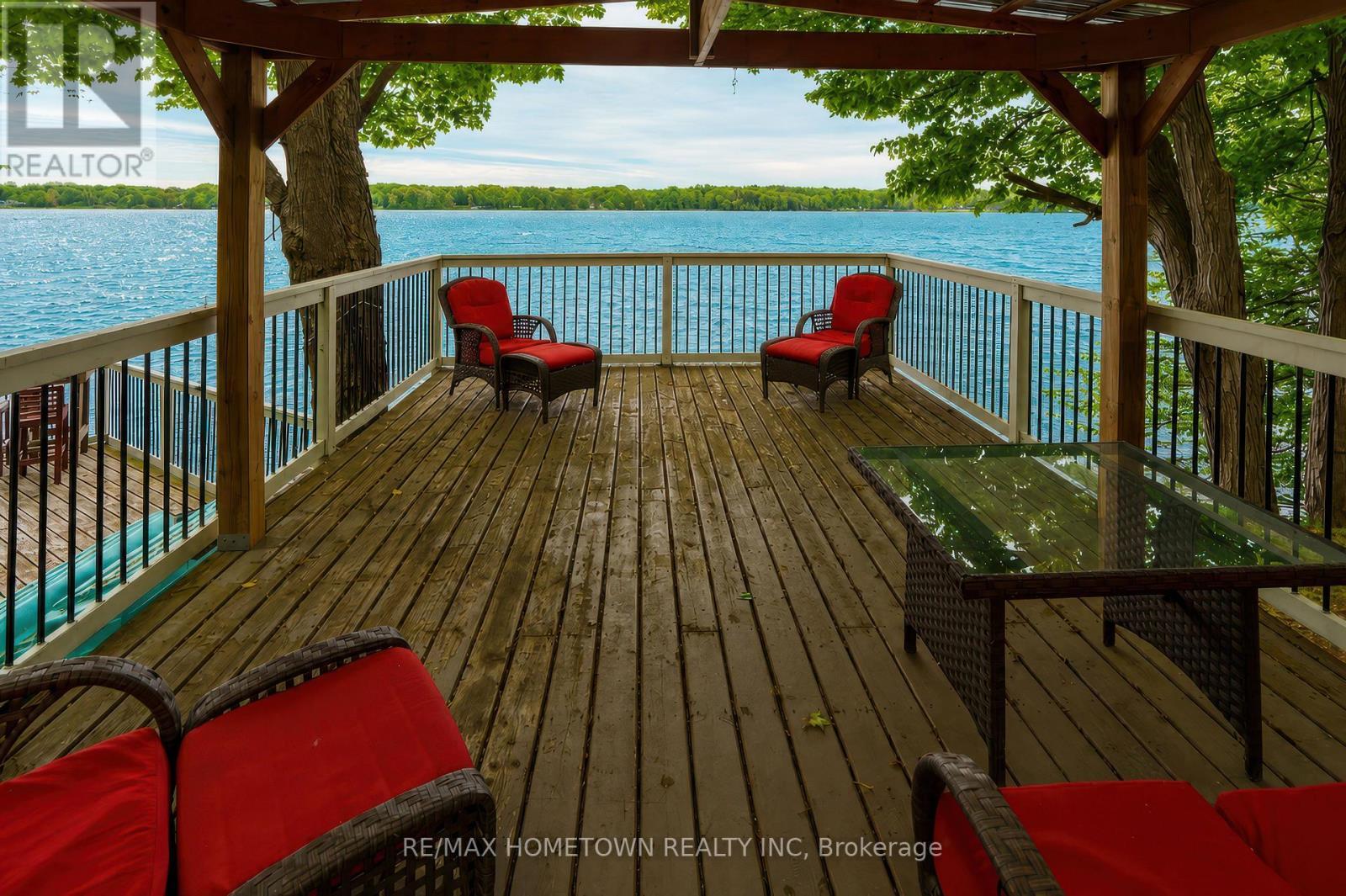 Could be perfect for your lakeside sunset dinners - 66 Scott Lane, Rideau Lakes, ON - Outdoor With Body Of Water With Deck Patio Veranda With View
