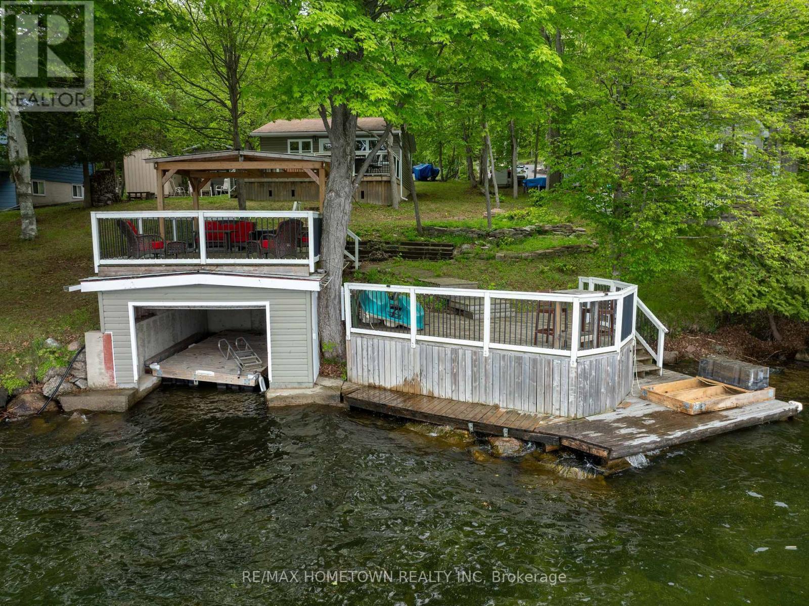 Single wet slip boathouse with plenty of mooring - 66 Scott Lane, Rideau Lakes, ON - Outdoor With Deck Patio Veranda