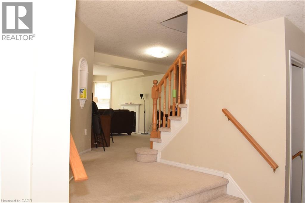 Carpeted staircase with wood handrails and balusters - 720 Brookmill Place, Waterloo, ON - Indoor Photo Showing Other Room