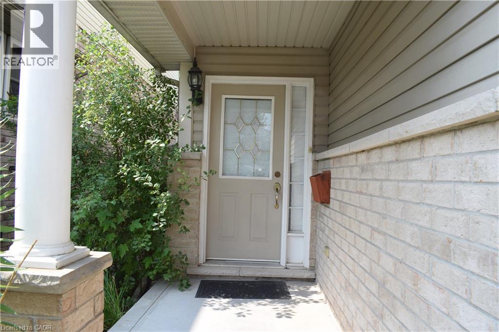 Front entryway featuring a decorative glass door, sidelight, and an exterior wall light fixture - 720 Brookmill Place, Waterloo, ON - Outdoor With Exterior