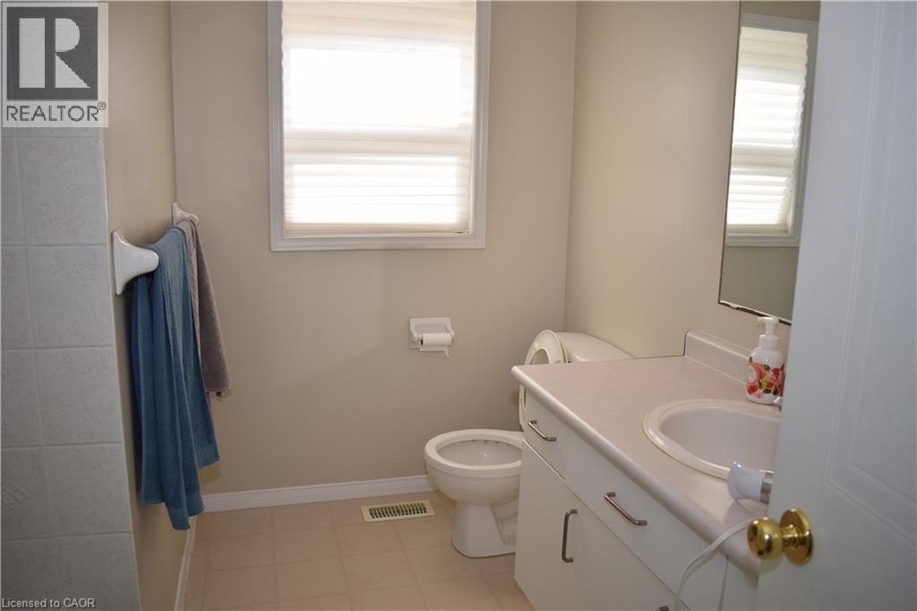 Bathroom featuring a vanity with integrated sink, a window with horizontal blinds, and tile flooring - 720 Brookmill Place, Waterloo, ON - Indoor Photo Showing Bathroom