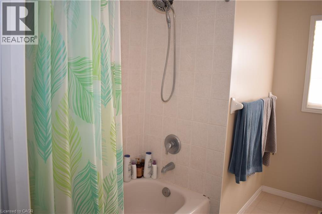 Bathtub with tiled surround and an integrated shower fixture - 720 Brookmill Place, Waterloo, ON - Indoor Photo Showing Bathroom