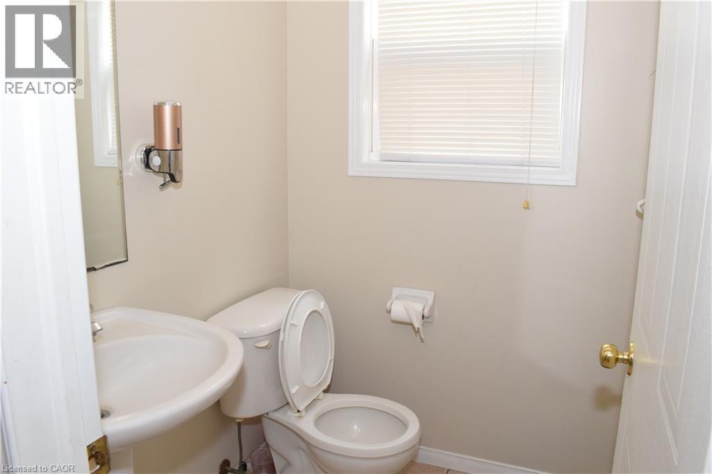 White ceramic toilet, pedestal sink, and window with horizontal blinds - 720 Brookmill Place, Waterloo, ON - Indoor Photo Showing Bathroom
