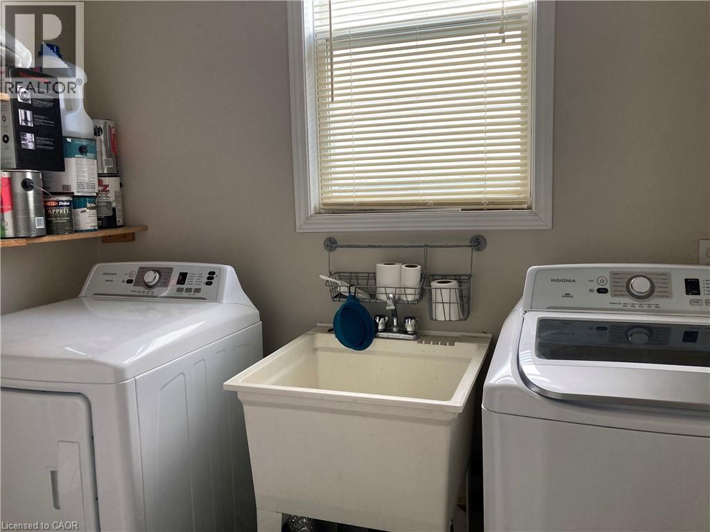 Utility sink with chrome faucet, paired with white laundry appliances - 720 Brookmill Place, Waterloo, ON - Indoor Photo Showing Laundry Room