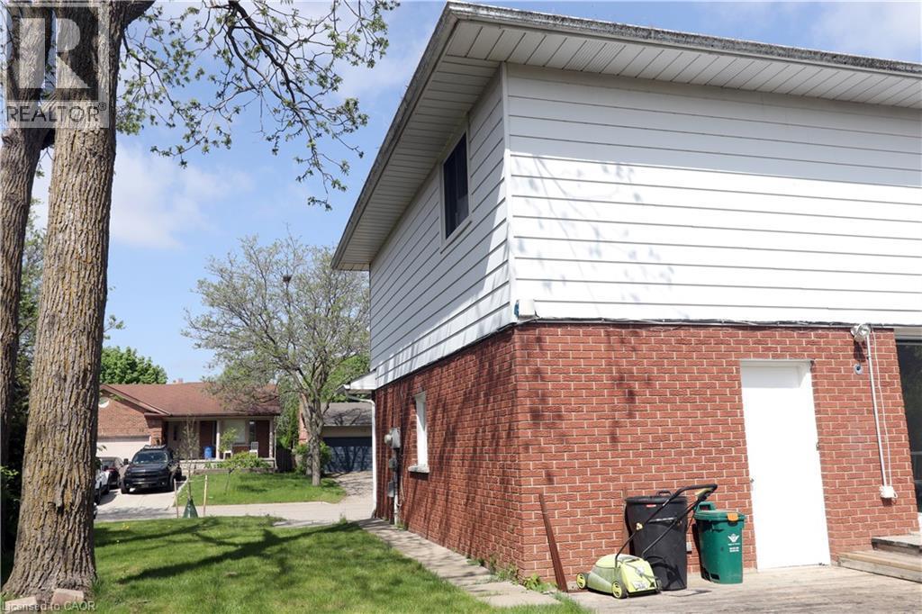 Brick and siding exterior with a side entry door - 77 Orchard Mill Crescent, Kitchener, ON - Outdoor With Exterior