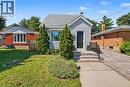 Gable roofline, light-colored siding, front entry steps with railing, established front landscaping, and a paved driveway - 16 Mercer Road, Cambridge, ON  - Outdoor 