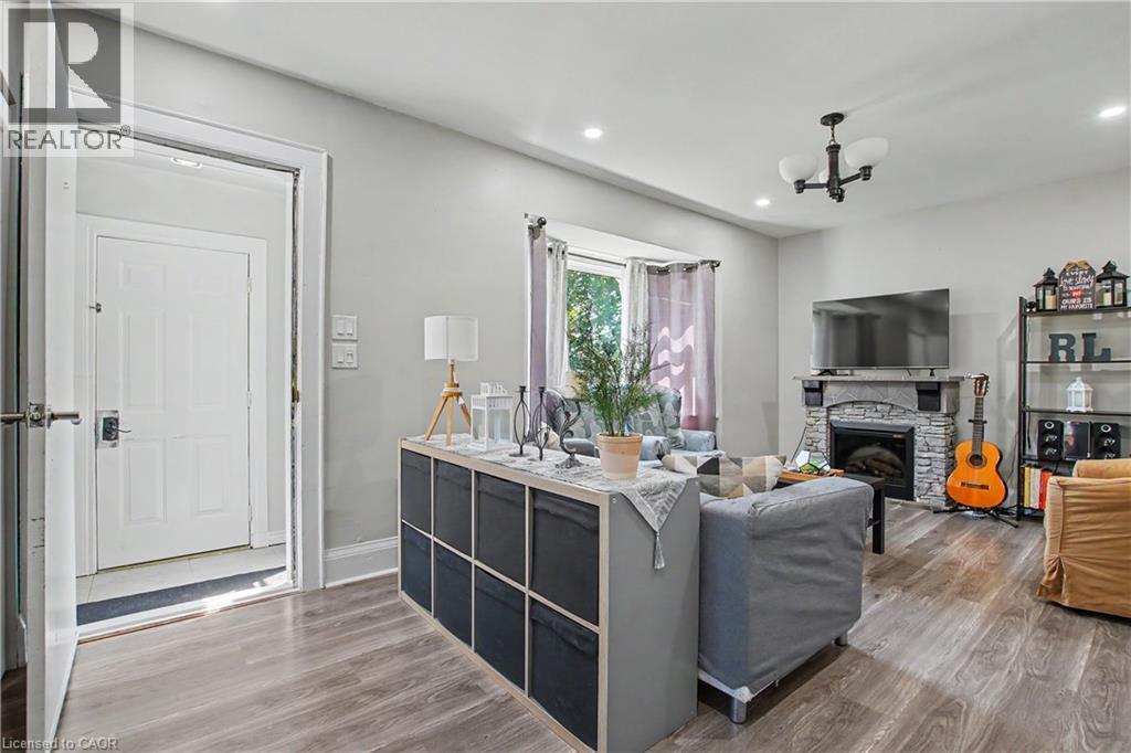 Wood-finish flooring, recessed lighting, and a stone-clad fireplace with a mantel - 16 Mercer Road, Cambridge, ON - Indoor With Fireplace