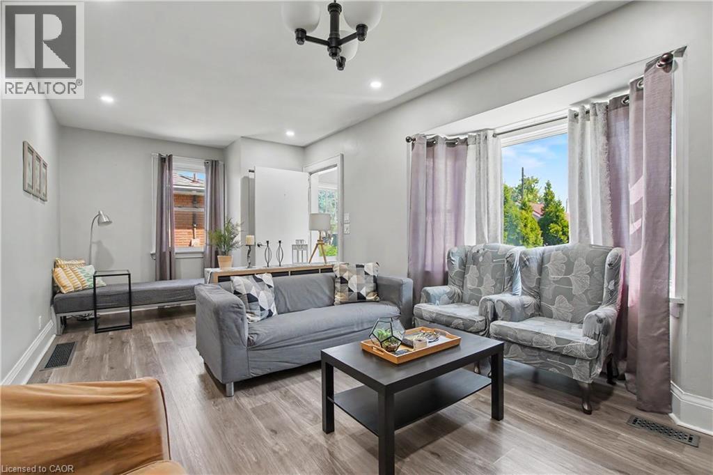 Spacious living area featuring durable wood-finish flooring, recessed lighting, and a prominent window - 16 Mercer Road, Cambridge, ON - Indoor Photo Showing Living Room