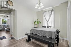 Recessed lighting, wood-finish flooring, and a multi-light ceiling fixture enhance this dining space -