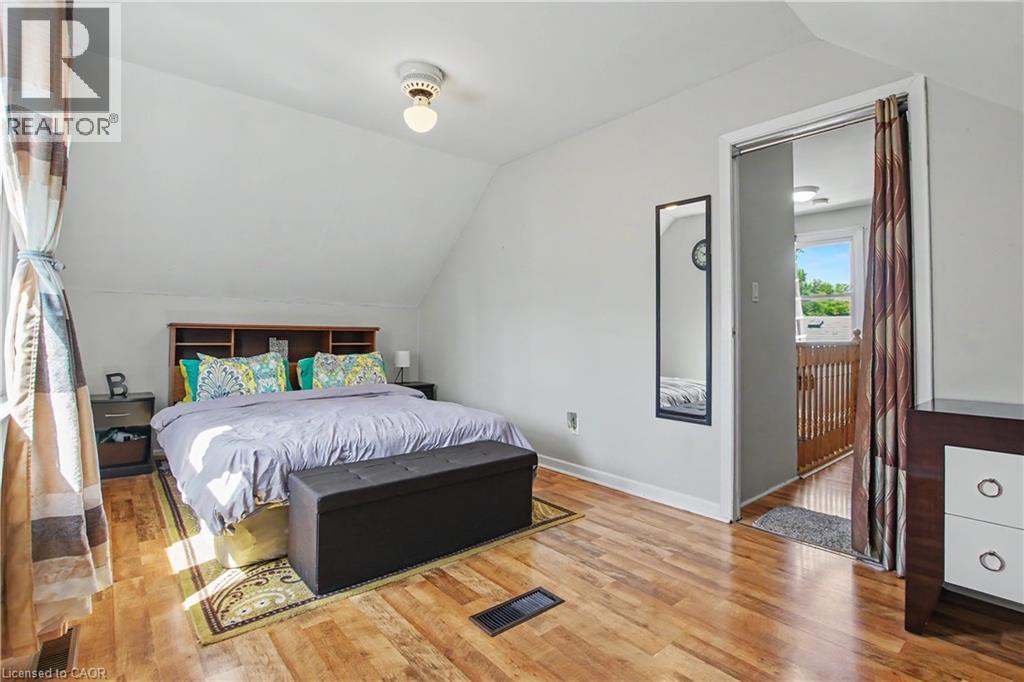 Wood-finish flooring with a light gray wall color, showcasing an attic room with sloped ceilings - 16 Mercer Road, Cambridge, ON - Indoor Photo Showing Bedroom