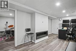 Recessed lighting, wood-finish flooring, white paneled door, and a built-in media niche -
