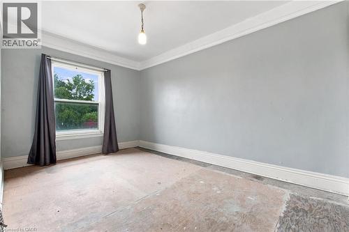 Neutral wall paint, crown molding, and base molding - 128 Hess Street N, Hamilton, ON - Indoor Photo Showing Other Room