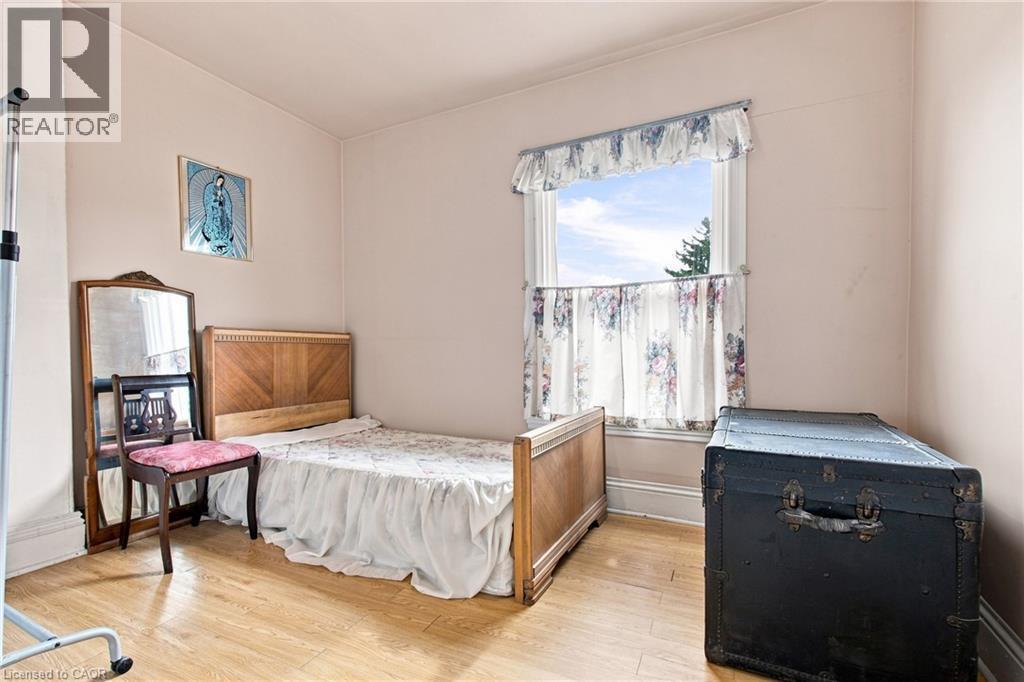 Wood-finish flooring with light-toned walls - 128 Hess Street N, Hamilton, ON - Indoor Photo Showing Bedroom
