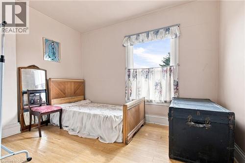 Wood-finish flooring with light-toned walls - 128 Hess Street N, Hamilton, ON - Indoor Photo Showing Bedroom