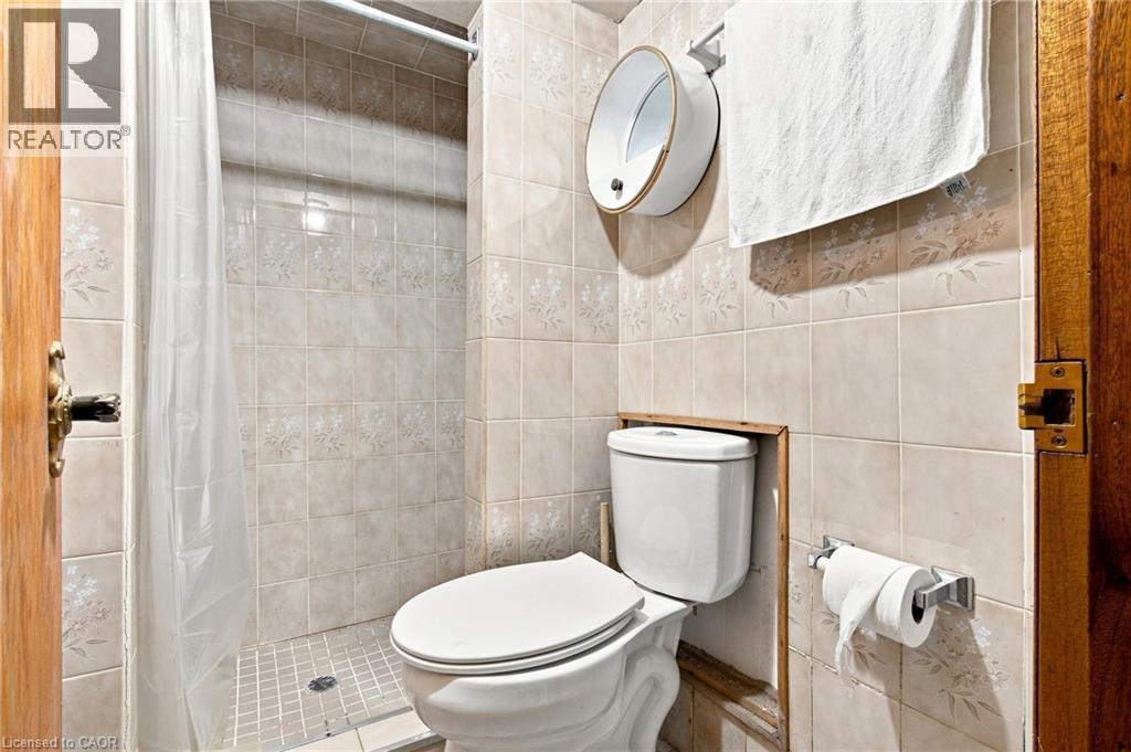 Ceramic tile shower surround with floral detailing and a tiled shower pan - 128 Hess Street N, Hamilton, ON - Indoor Photo Showing Bathroom