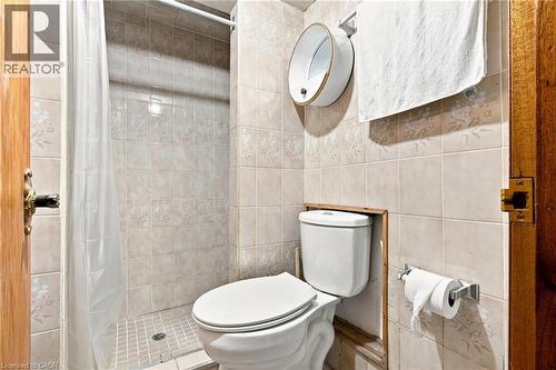 Ceramic tile shower surround with floral detailing and a tiled shower pan - 128 Hess Street N, Hamilton, ON - Indoor Photo Showing Bathroom