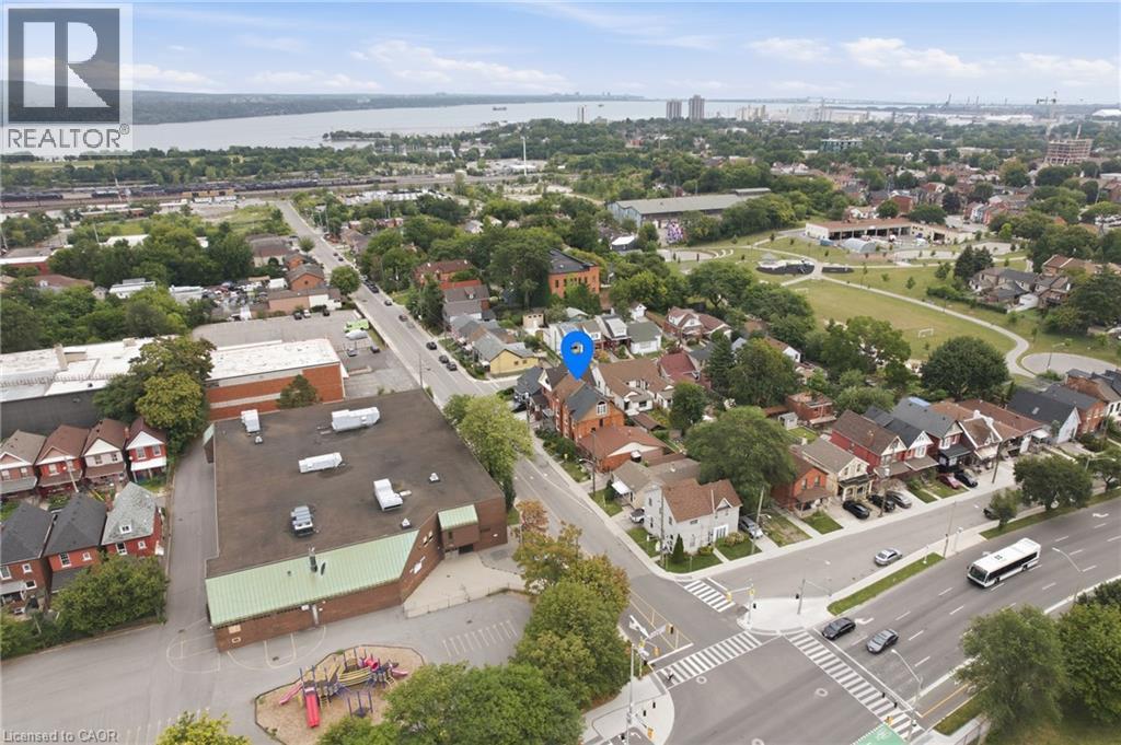 Aerial perspective featuring a residential neighborhood, institutional buildings, and Lake Ontario. - 128 Hess Street N, Hamilton, ON - Outdoor With View