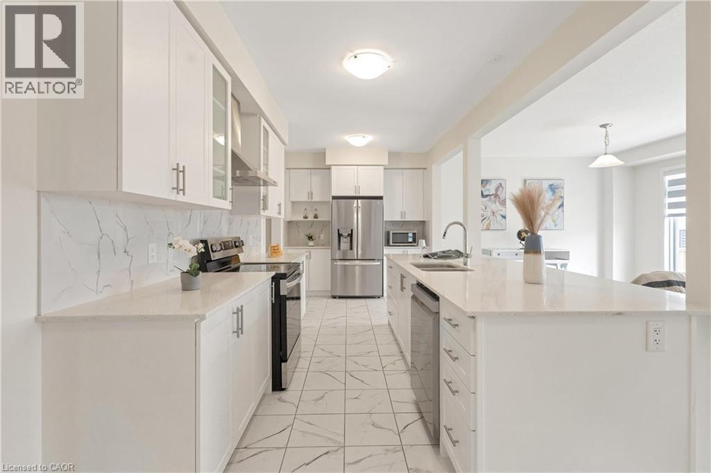Kitchen with white cabinetry, stainless steel appliances, light-toned countertops, and a tile backsplash - 285 Broadacre Drive, Kitchener, ON - Indoor Photo Showing Kitchen With Double Sink With Upgraded Kitchen