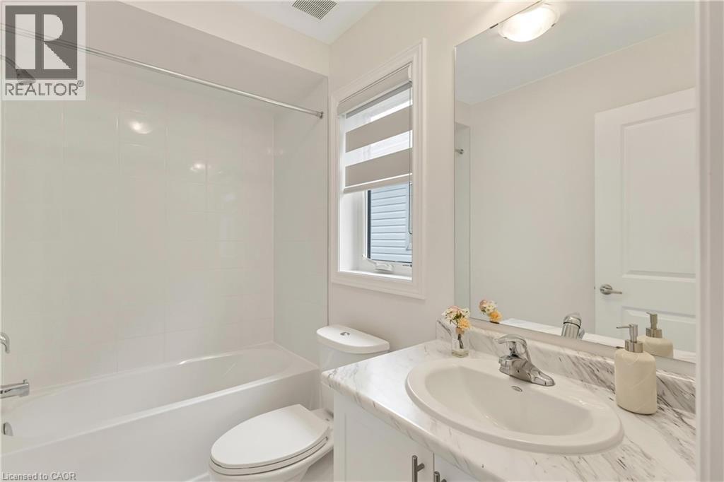White tile bath and shower combination with chrome fixtures - 285 Broadacre Drive, Kitchener, ON - Indoor Photo Showing Bathroom