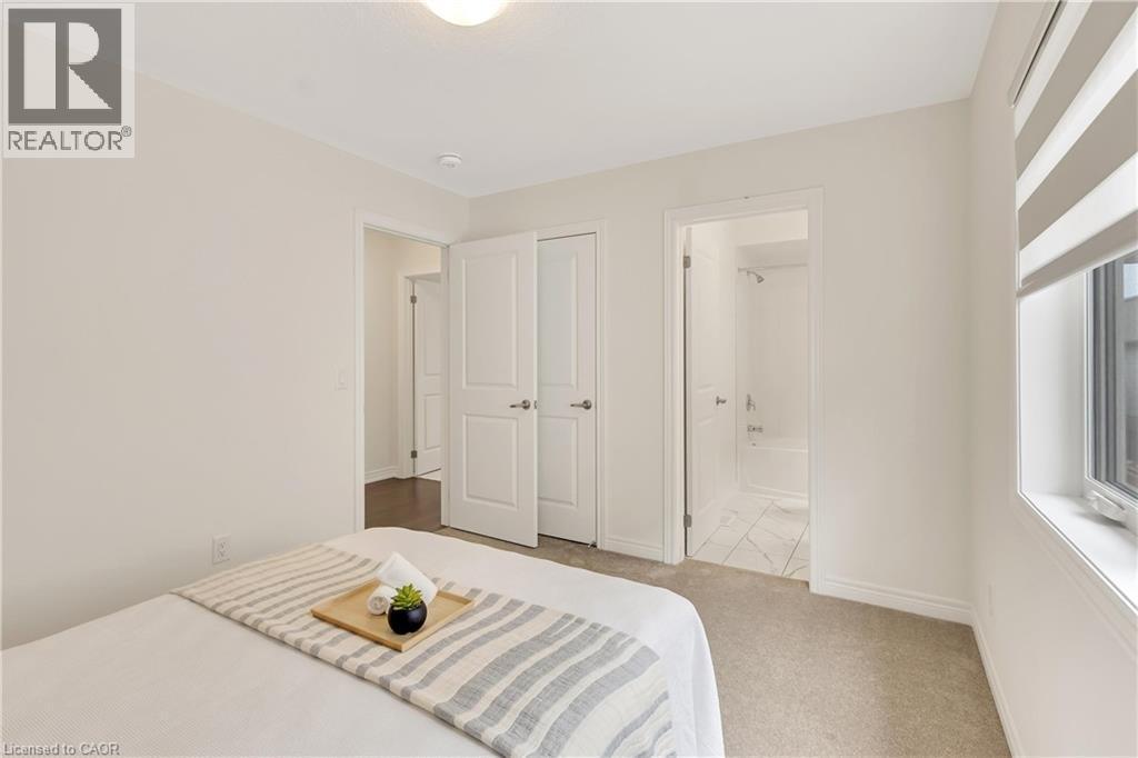 Light-colored carpeting with white baseboards, a window with roller blinds, and a white interior door - 285 Broadacre Drive, Kitchener, ON - Indoor Photo Showing Bedroom