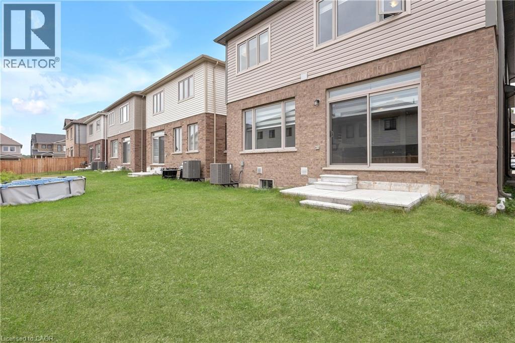 Expansive green space featuring brick and siding exterior, sliding glass door, and exterior steps - 285 Broadacre Drive, Kitchener, ON - Outdoor
