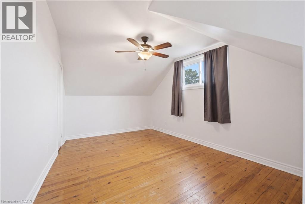 Bedroom featuring hardwood flooring, white painted walls, and a ceiling fan with integrated lighting - 481 Upper Gage Avenue, Hamilton, ON - Indoor Photo Showing Other Room