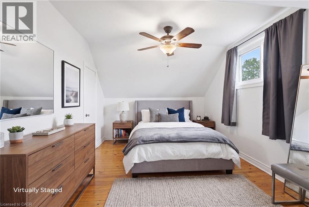 Bedroom featuring hardwood flooring, white painted walls, and a ceiling fan with integrated lighting - 481 Upper Gage Avenue, Hamilton, ON - Indoor Photo Showing Bedroom
