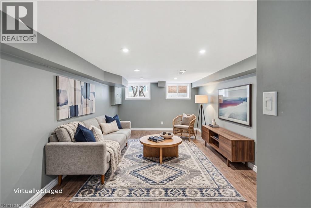 Finished lower level featuring recessed lighting, wood-finish flooring, light gray wall paint, and two windows providing natural light - 481 Upper Gage Avenue, Hamilton, ON - Indoor