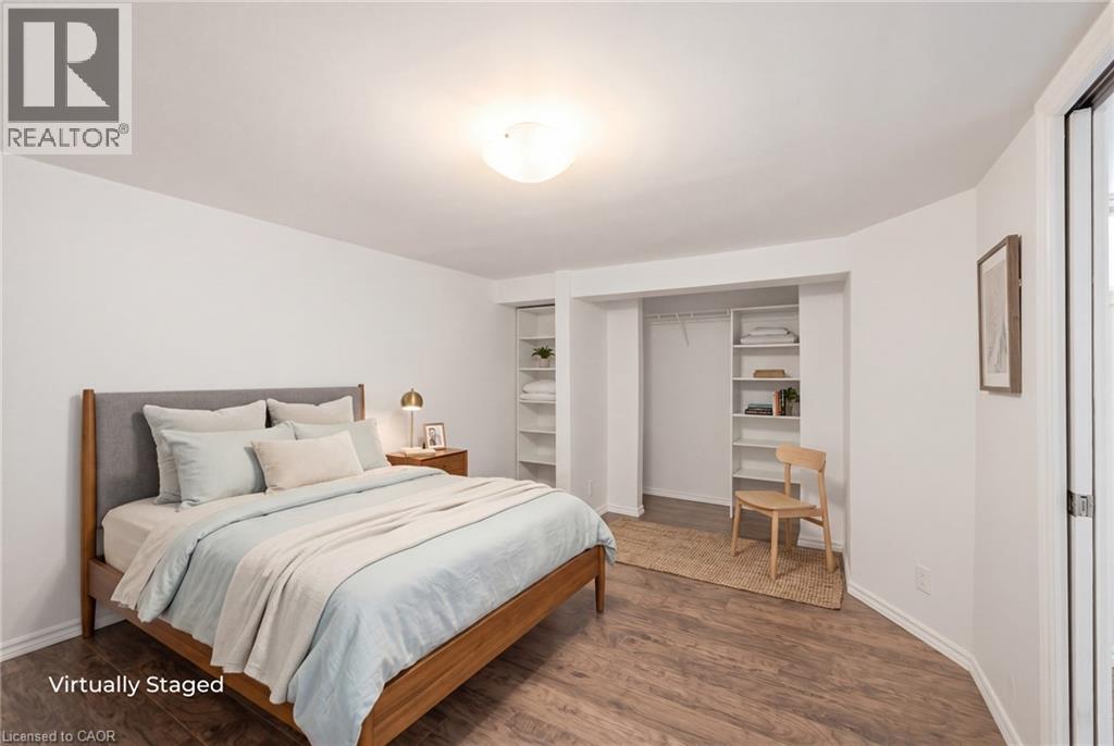 Basement Bedroom featuring wood-finish flooring, white baseboards, and a large closet - 481 Upper Gage Avenue, Hamilton, ON - Indoor Photo Showing Bedroom