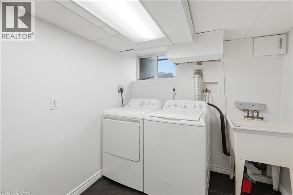 Dedicated laundry area featuring a utility sink, a window, and overhead fluorescent lighting - 481 Upper Gage Avenue, Hamilton, ON - Indoor Photo Showing Laundry Room