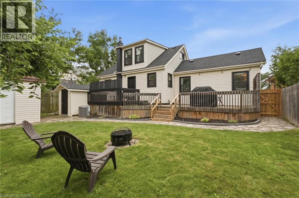Expansive backyard featuring a wood privacy fence, stone pathway, and a multi-level wooden deck with steps - 481 Upper Gage Avenue, Hamilton, ON - Outdoor With Deck Patio Veranda