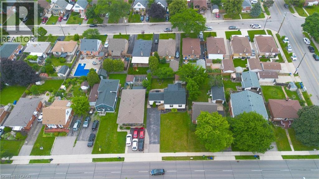 Aerial perspective highlighting a residential neighbourhood with diverse architectural styles, mature trees, and paved roadways - 481 Upper Gage Avenue, Hamilton, ON - With View