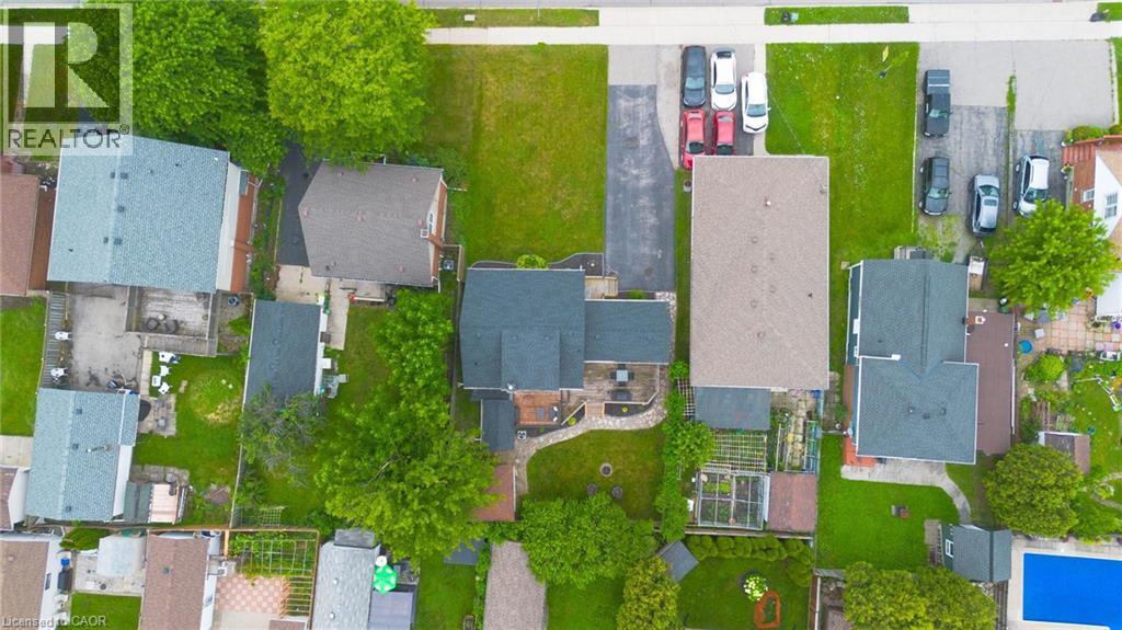Aerial perspective showcasing the property's roofline, surrounding green spaces, and paved driveway - 481 Upper Gage Avenue, Hamilton, ON - With View
