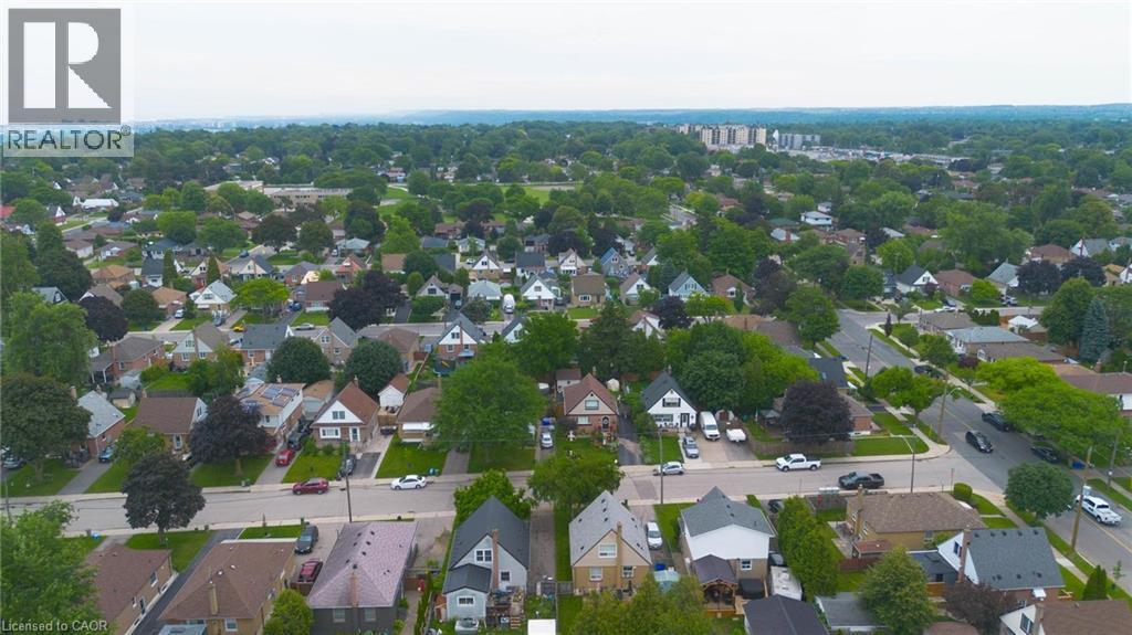 Aerial perspective highlighting a residential neighbourhood with diverse architectural styles, mature trees, and paved roadways - 481 Upper Gage Avenue, Hamilton, ON - Outdoor With View