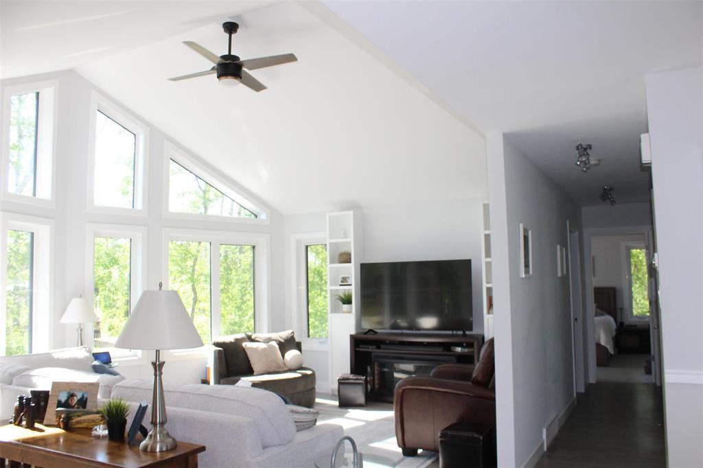 Stunning wall of windows allows for so much natural light. No need for blinds as the property is almost hidden from the road from all the trees. - 7 Dalvik Road, Gimli Rm, MB - Indoor Photo Showing Living Room