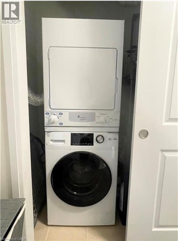 Stacked washer and dryer unit within an enclosed closet - 17 Visionary Avenue, Kitchener, ON - Indoor Photo Showing Laundry Room