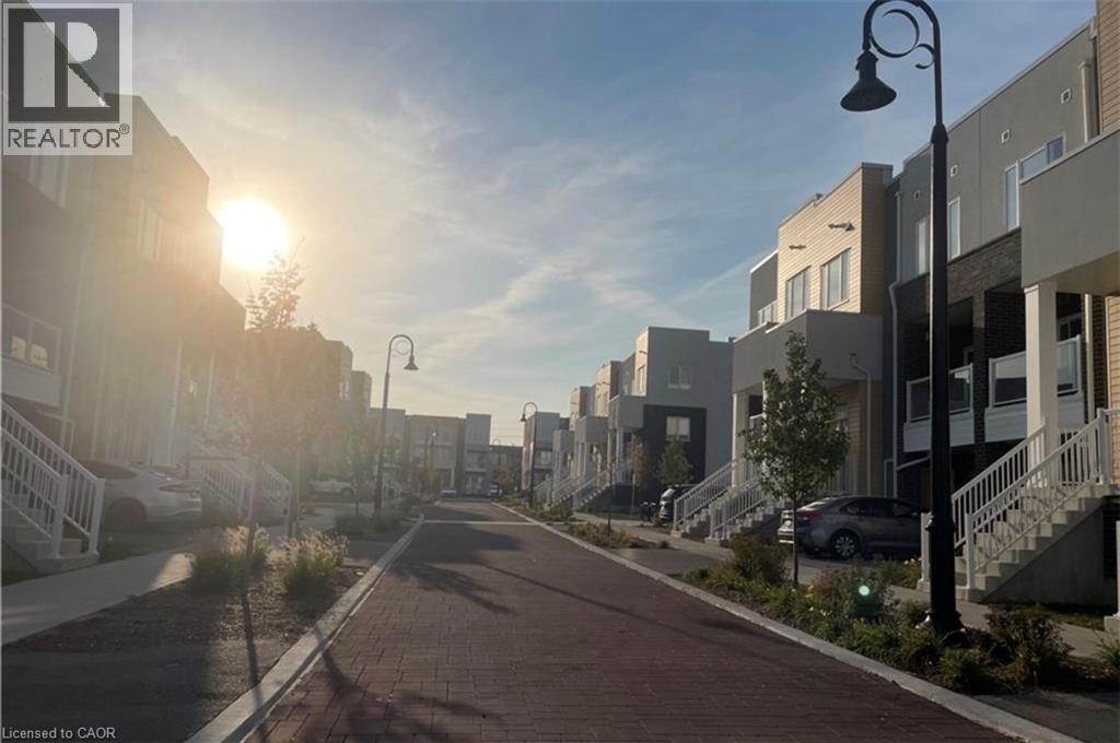 Brick paver pathway with street lighting, flanked by multi-story residential buildings featuring various exterior finishes - 17 Visionary Avenue, Kitchener, ON - Outdoor