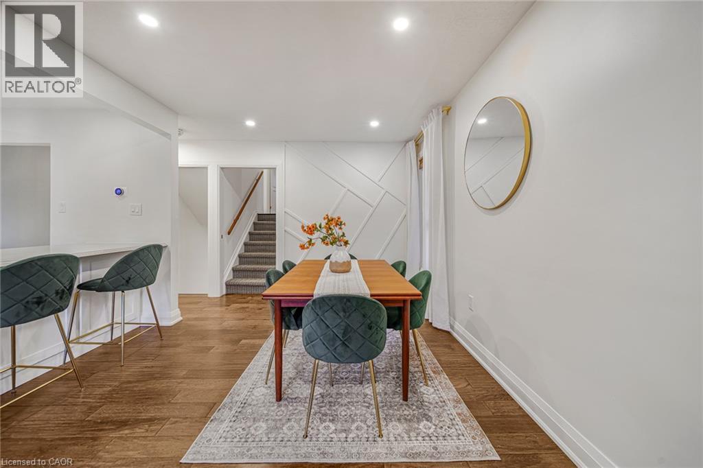 Wood-finish flooring, recessed lighting, and a decorative accent wall create a refined atmosphere - 24 Garvey Crescent, Hamilton, ON - Indoor Photo Showing Other Room
