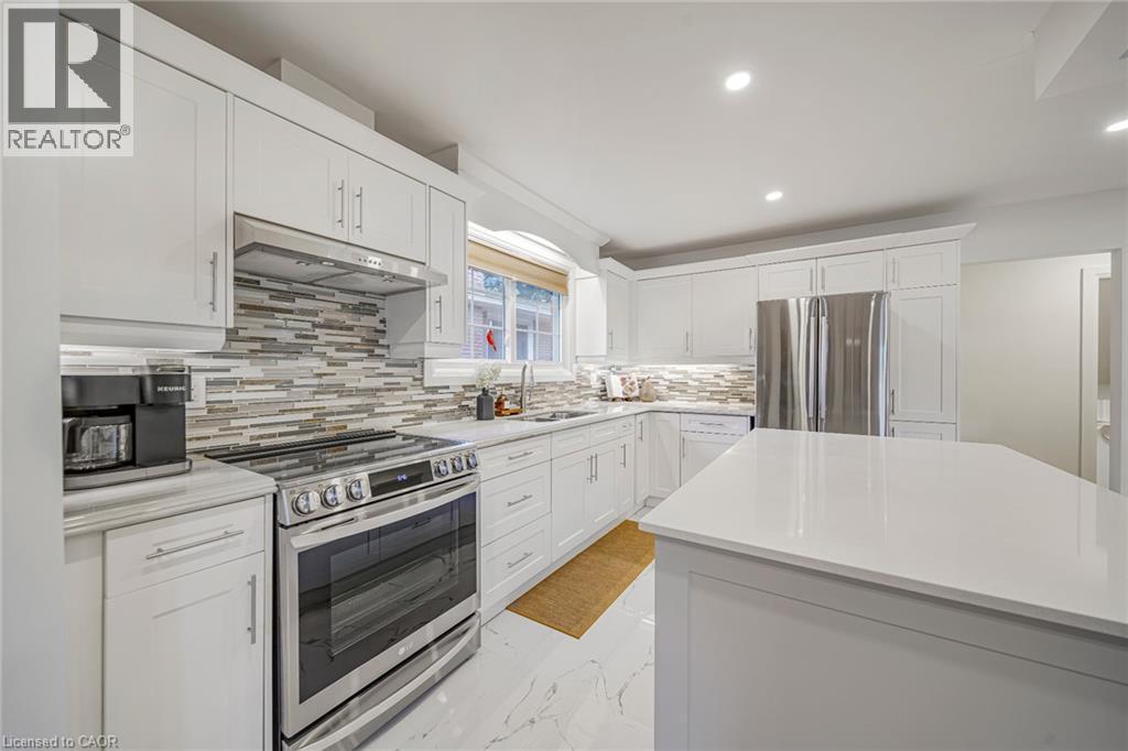 Kitchen featuring white cabinetry, stainless steel appliances, a multi-tone tile backsplash, white countertops, and recessed lighting - 24 Garvey Crescent, Hamilton, ON - Indoor Photo Showing Kitchen With Upgraded Kitchen