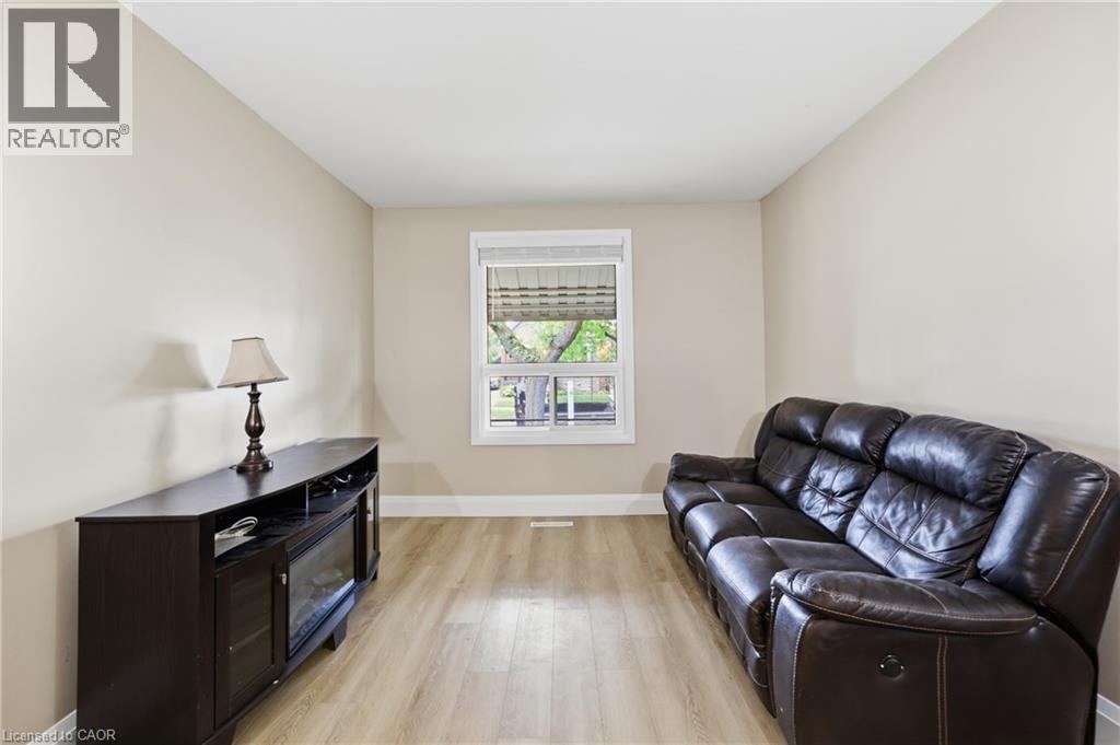 Neutral-toned walls complement wood-finish flooring - 56 Harmony Avenue, Hamilton, ON - Indoor Photo Showing Living Room