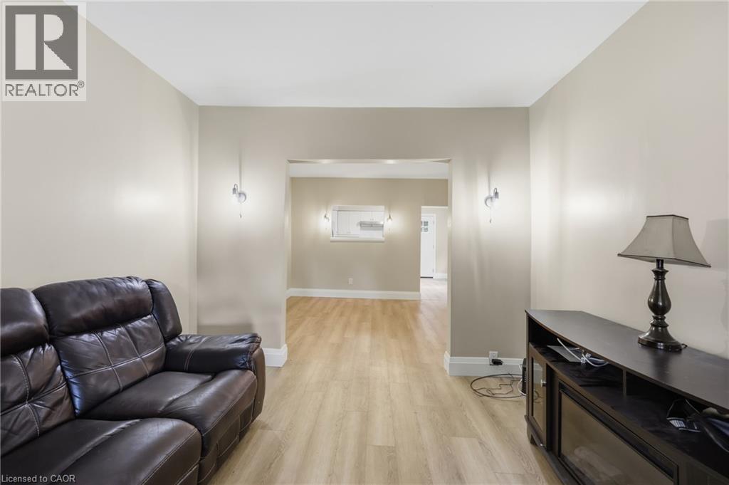 Neutral-toned walls with wood-finish flooring and recessed lighting - 56 Harmony Avenue, Hamilton, ON - Indoor Photo Showing Other Room