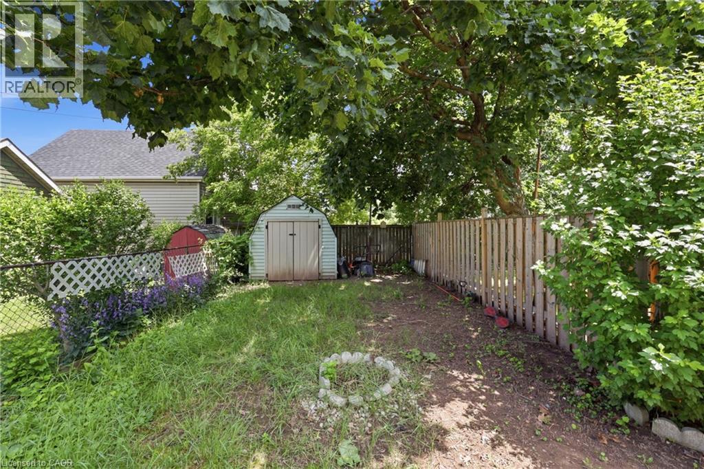 Rear yard featuring a garden shed, mature trees, and a privacy fence - 56 Harmony Avenue, Hamilton, ON - Outdoor