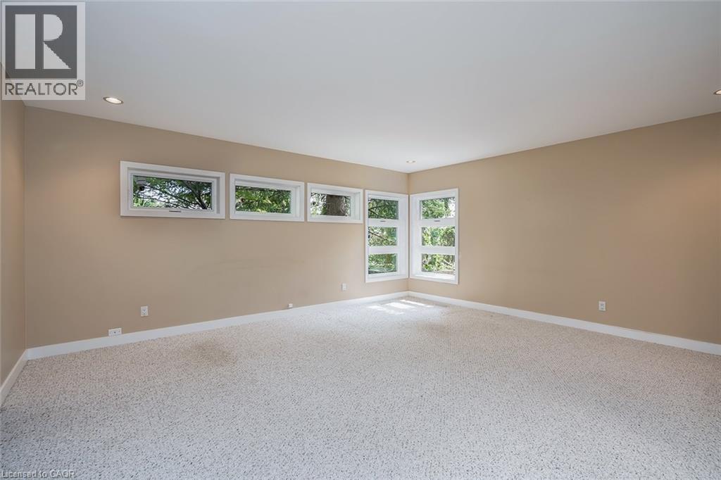 Light-colored carpeting, recessed ceiling lighting, and multiple windows with white trim - 4189 Inglewood Drive, Burlington, ON - Indoor Photo Showing Other Room